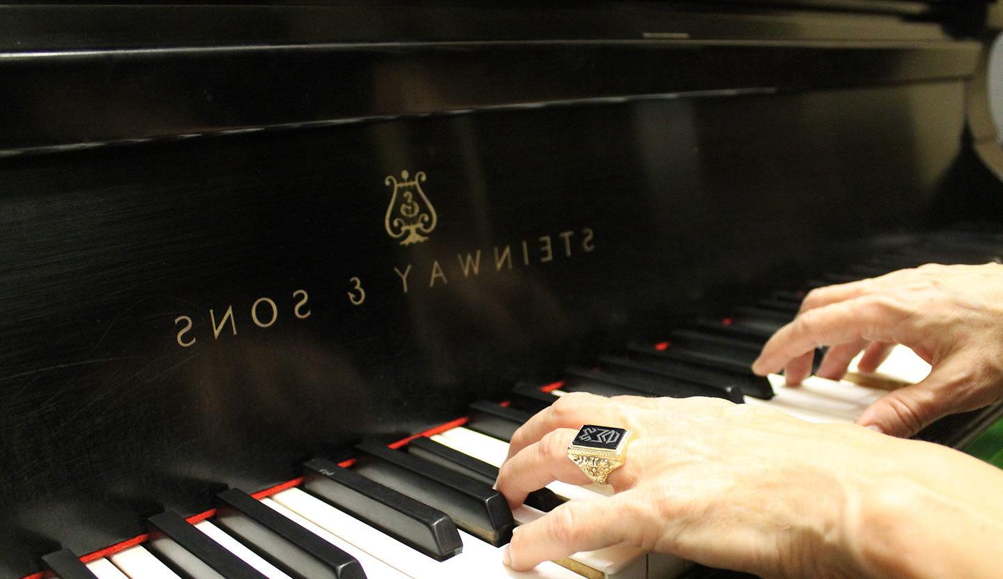 Hands wearing Woods ring playing Steinway piano