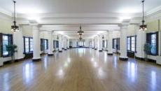 The beautiful, large Le Fer Hall Ballroom with the chandeliers, columns and wood floors.